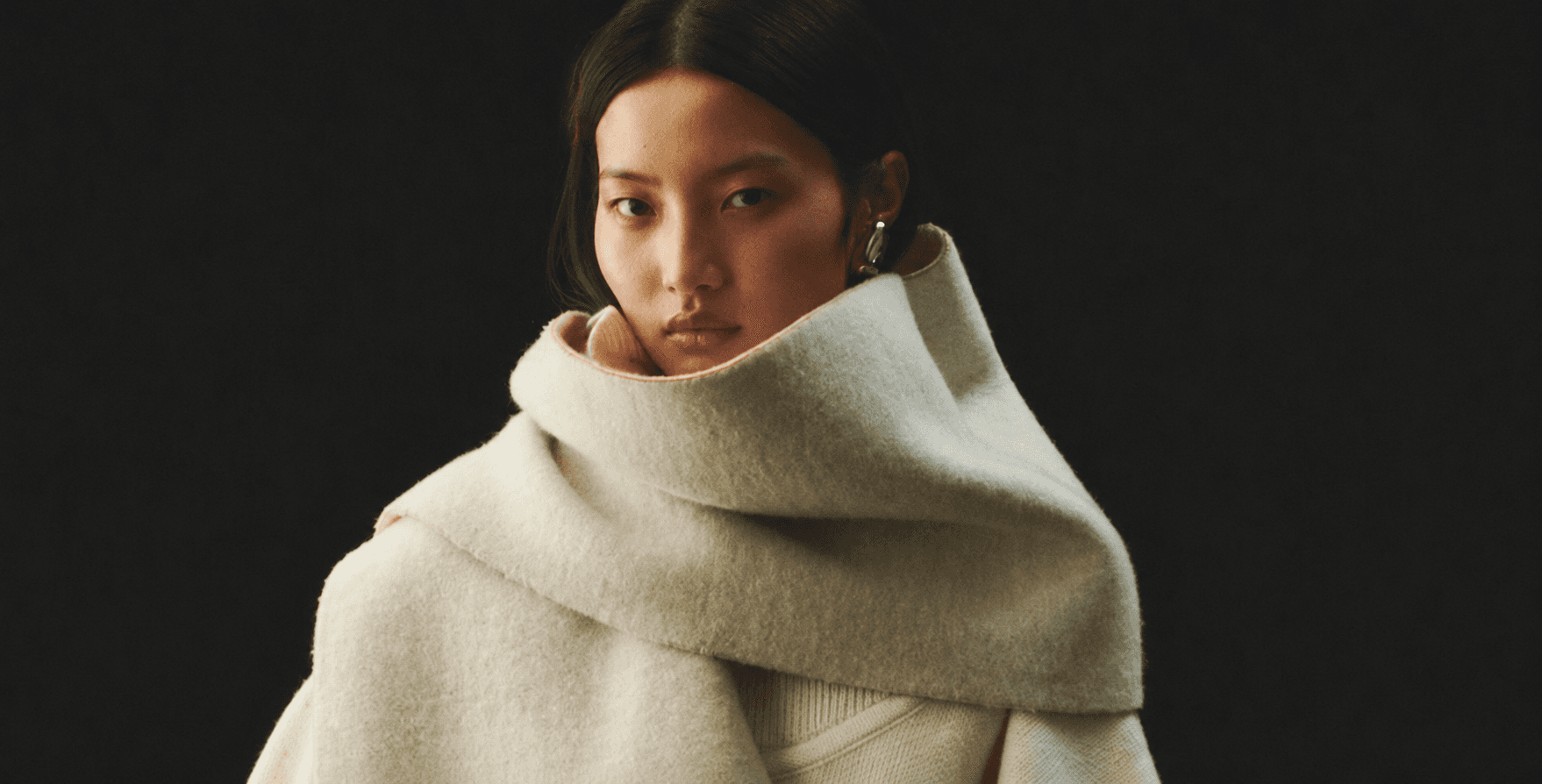 Model wrapped in a cream cashmere scarf